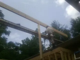Carpenter setting a ridge beam over a new addition frame — Ice Dam Removal by Roofing Brothers in Loves Park