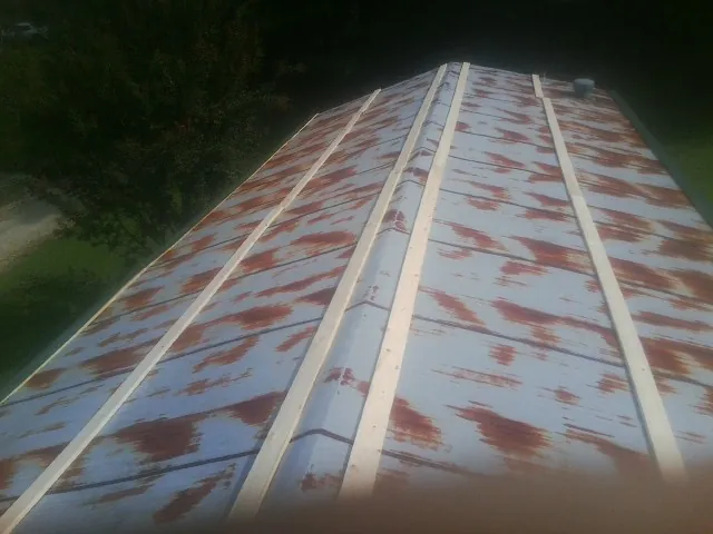 Rusted metal roof panels with new wood purlins before replacement — Storm Damage Roof Repair in Loves Park by Roofing Brothers