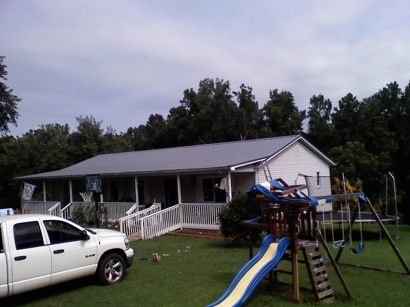 Dark metal roof on a country home with a full length front porch in Loves Park