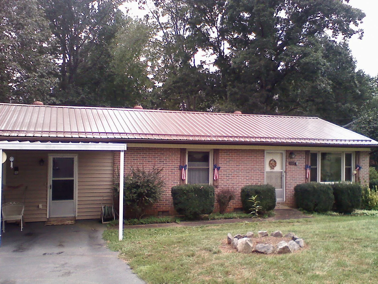 Bronze metal roof and carport on a brick ranch home — Roof Repair work by our crew in Loves Park